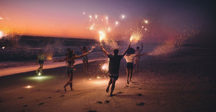 friend running with fireworks on a beach afer sunset